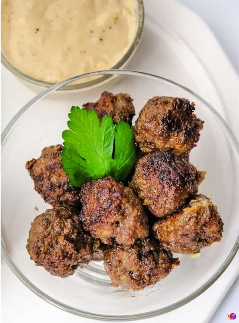 Meatballs in a bowl with Swedish Meatball Gravy on the side