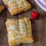 Puff Pastry Strawberry Strudel on a table with strawberries next to it