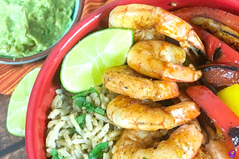 Shrimp Fajita Bowls with Cilantro-Lime Rice 4 Savor the Shrimp Fajita Bowls: a delightful mix of spiced shrimp and sliced bell peppers, served with brown rice, lime wedges, and a side of creamy guacamole.