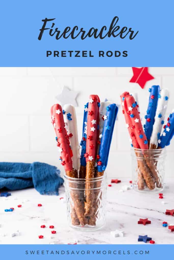 Glass jars filled with Firecracker Pretzel Rods coated in red, white, and blue candy with star-shaped sprinkles. Festive decorations and a blue cloth are visible on a white countertop, making these patriotic snacks perfect for any celebration.