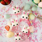 Chocolate Covered Strawberry Bunnies surrounded by Easter eggs and chocolate sprinkles