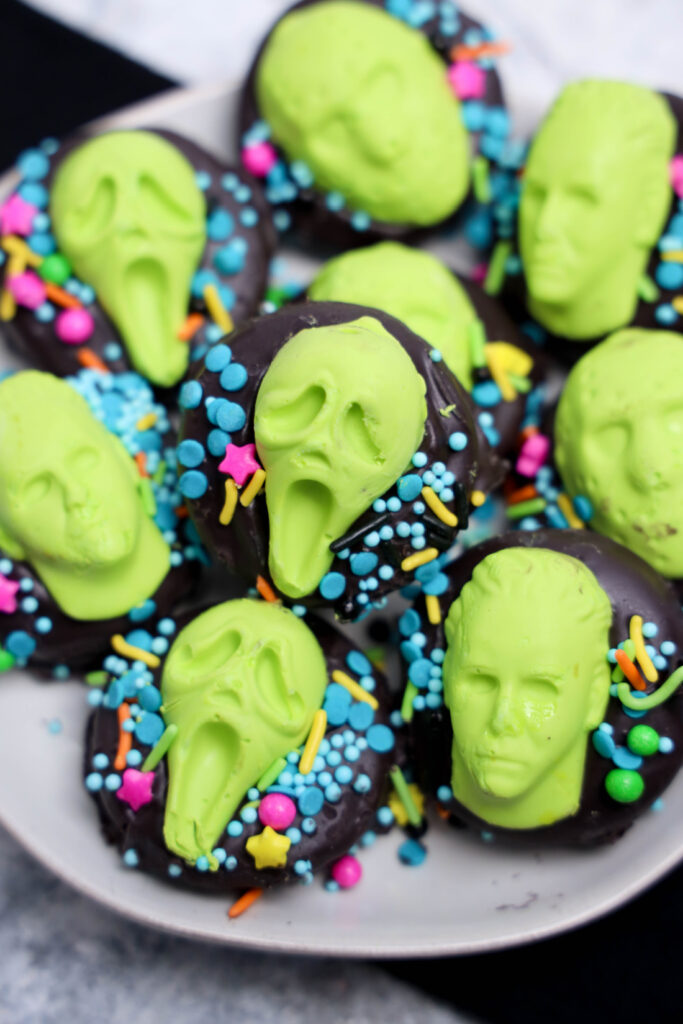 Summerween Slasher Oreos 9 A plate of Summerween Slasher Oreos decorated with bright green faces and colorful sprinkles captures the playful spirit of Summerween.